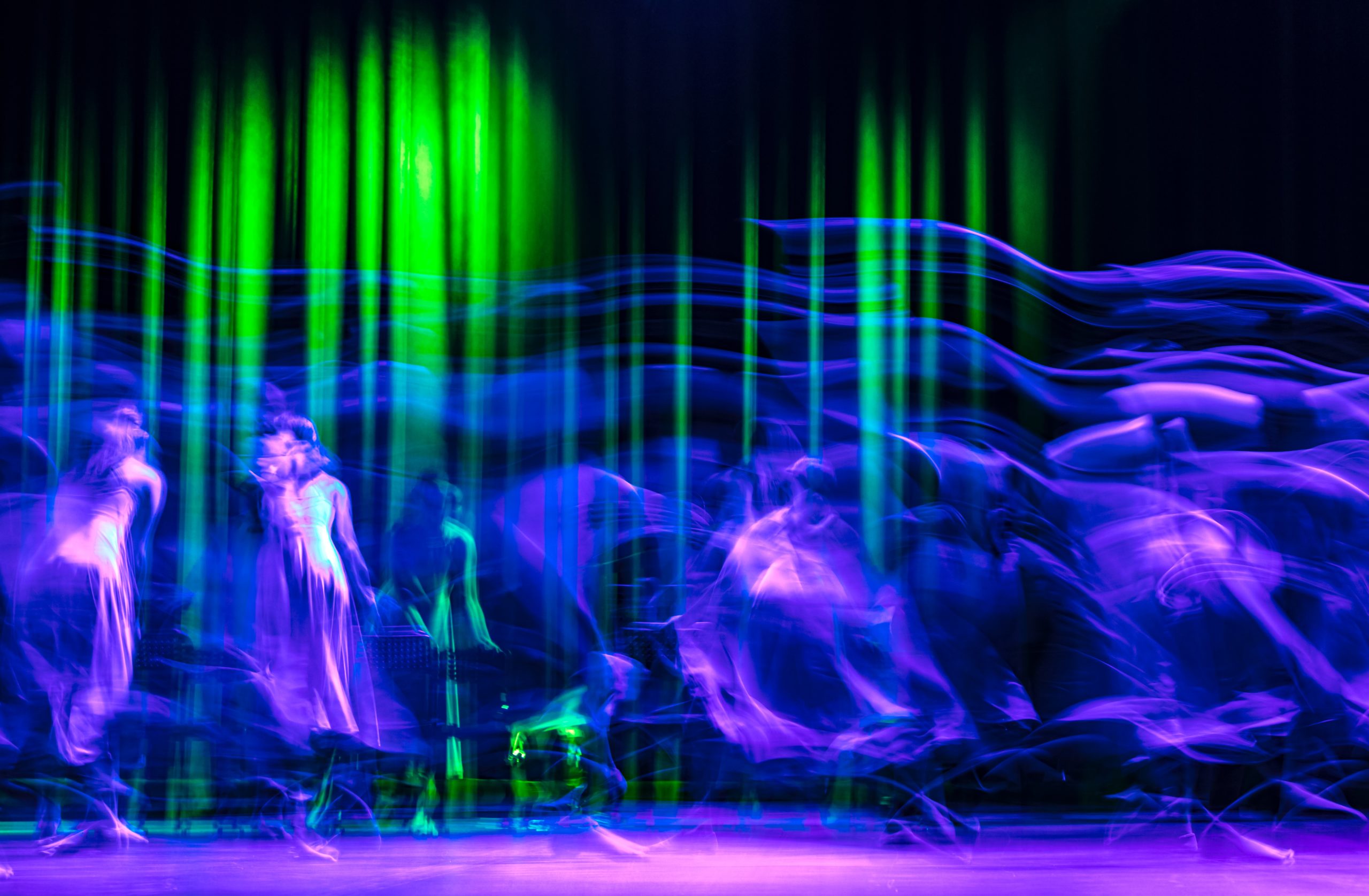 Verschwommenes Bild einer Bühnenszene in Blau, Grün und Lila-Tönen